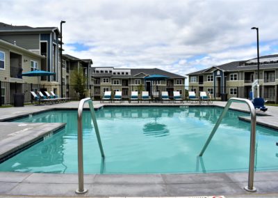 Glistening swimming pool with outdoor lounge areas at Copper Pointe Apartments in San Antonio