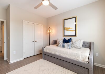 Decorated model apartment bedroom with a large walk-in closet and ceiling fan