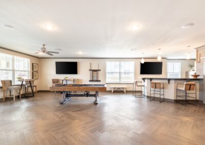 Resident community center with pool table, televisions, and bar island at Copper Pointe apartments in San Antonio, TX