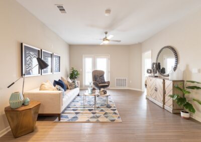 Model San Antonio apartment living room with couch, patio doors, and ceiling fan at Copper Pointe